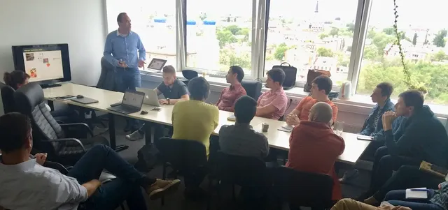 

Group of people around a table & laptop at an event. #Y