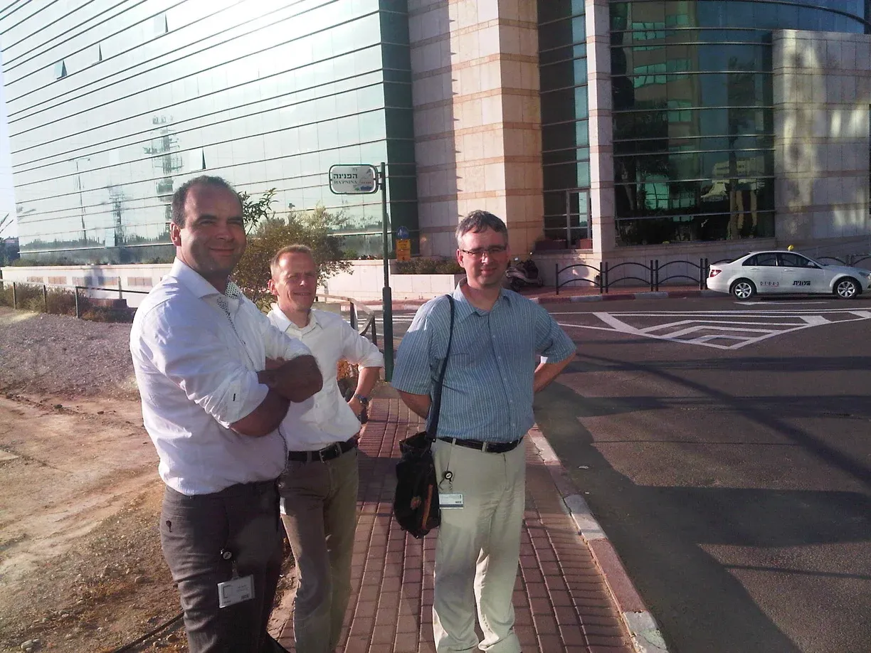 Smiling driver standing on tyre by car on road: "MAILLE