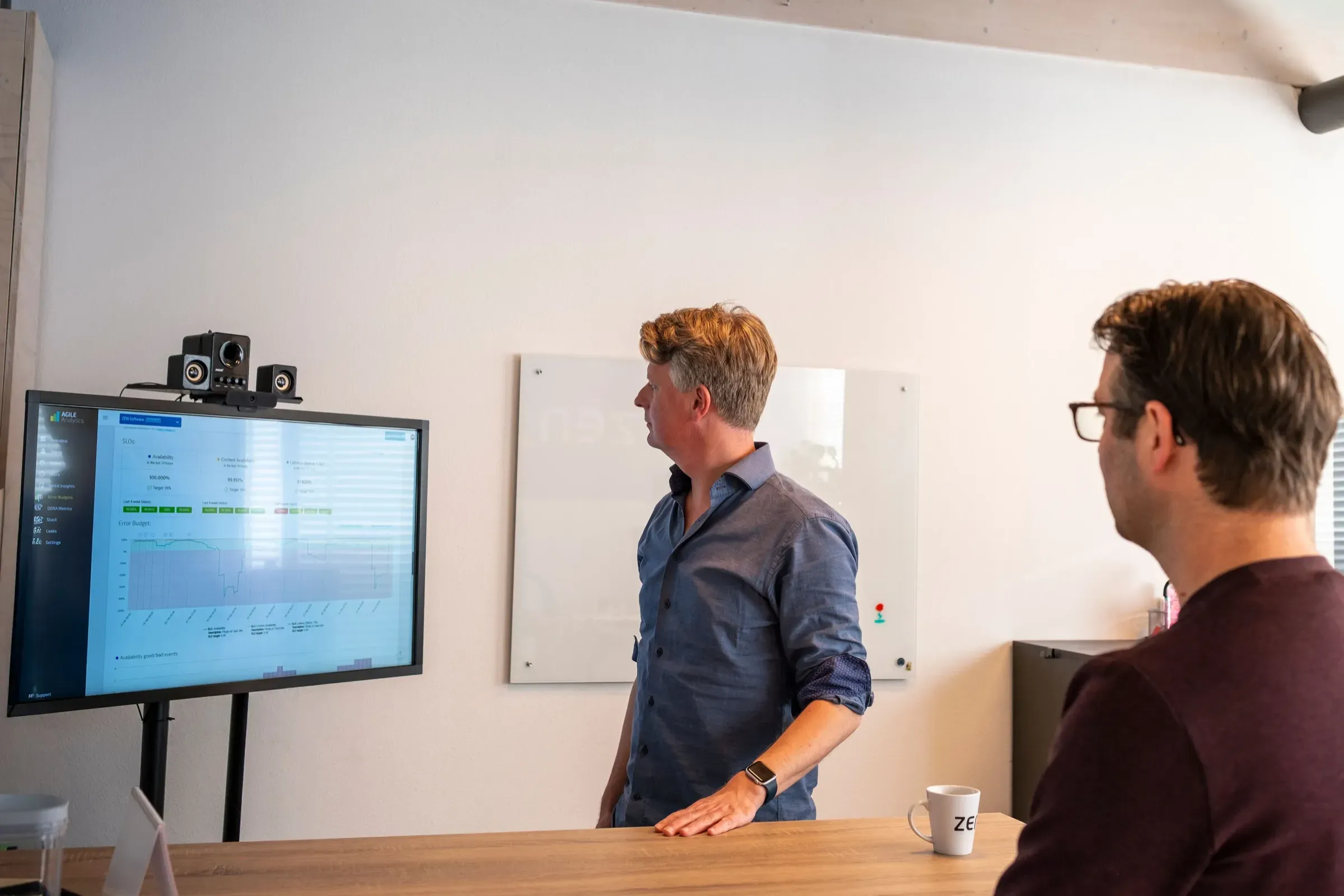 Twee collega's overleggen bij een scherm met data, op kantoor bij ZEN Software in Alkmaar