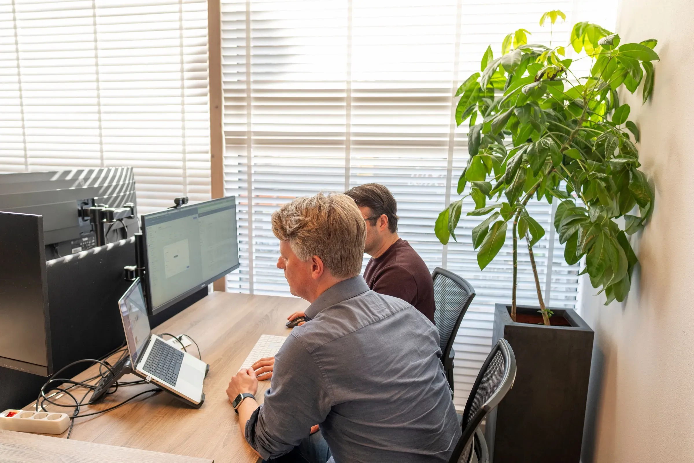 Twee engineers werken naast elkaar aan bureaus met meerdere schermen, in het kantoor van ZEN Software in Alkmaar.